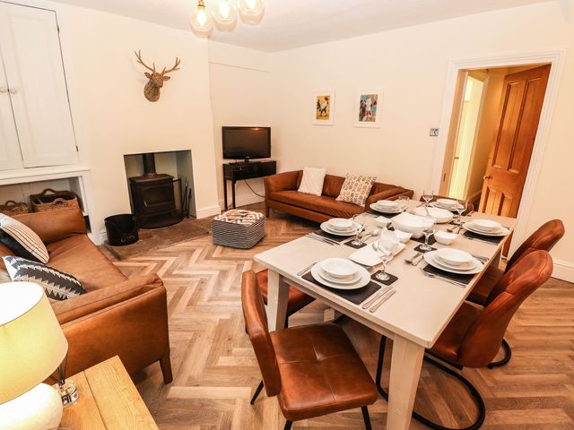 A dining room with a table set for meals at Waterhead Cottage in Ambleside