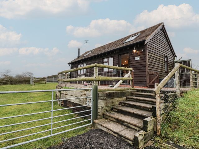 A cabin with steps leading to a fenced outdoor area at The Barn on The Lagoon Droitwich