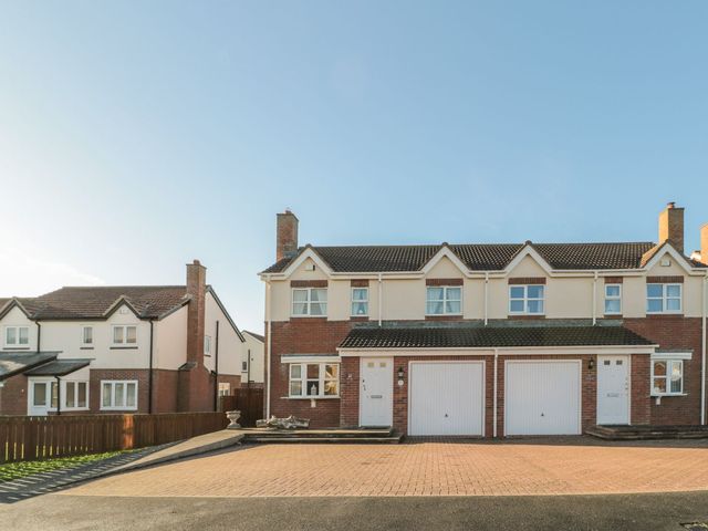 A house with a driveway and garages at Sandy Cove in Chathill