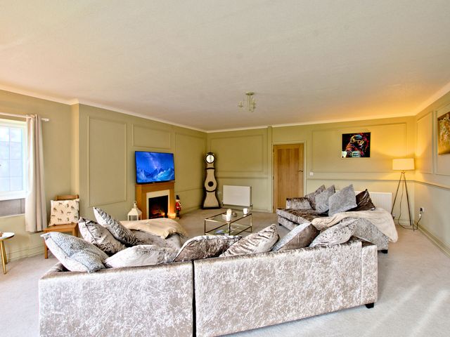 A living room with a sofa and television at River View Cottage, Hanlith near Malham