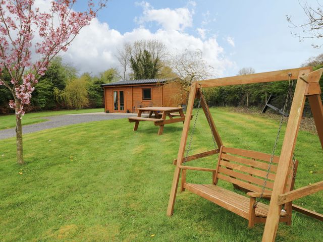 An outdoor area featuring a swing and picnic table at Nellies Log Cabin in Kilcogy