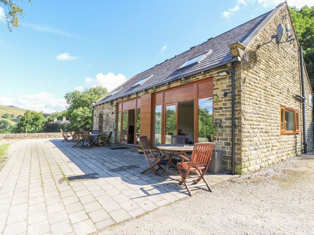 An outdoor patio with a stone building and furniture at Victoria Wood View Cragg Vale