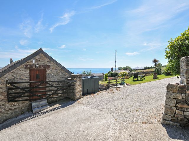 An outdoor area with a stone cottage and sea view at Casa Mia in Porthpean near St Austell