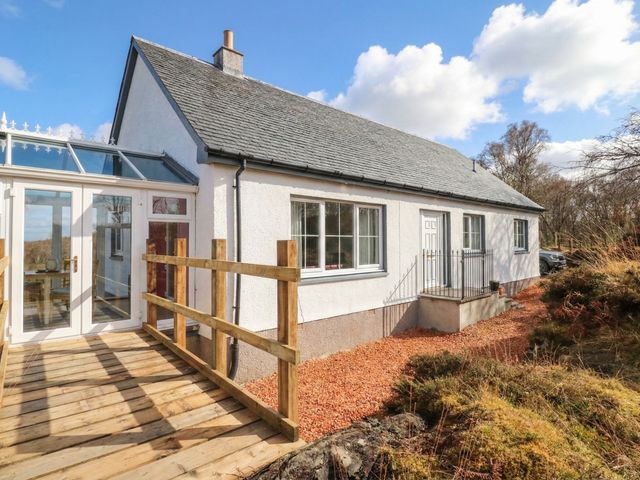 A house with a deck and gravel pathway at Doire An Daimh