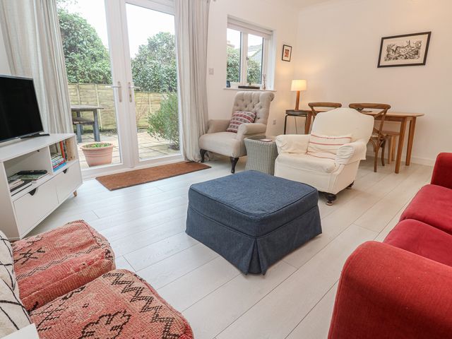 A living room with seating and a dining table at Pump Cottage in Truro