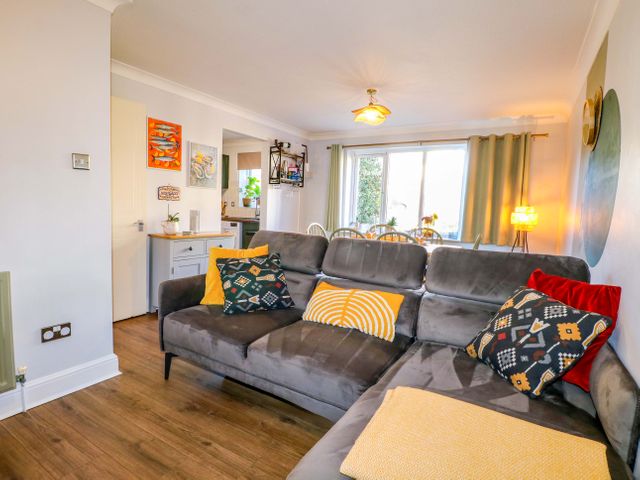 A living room with a sofa and dining area at Flat 16 in Farnham