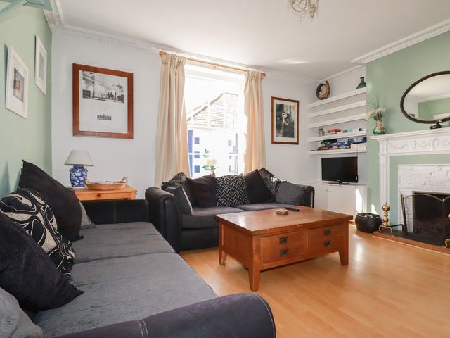 A living room with a sofa and coffee table at The Old Bank House in Mevagissey
