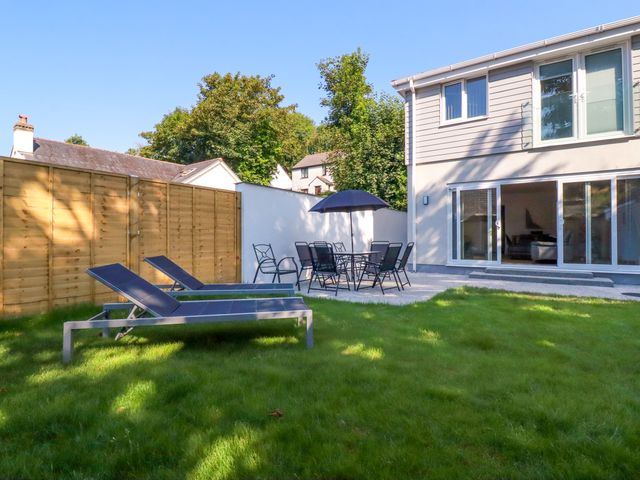 A garden with sun loungers and a dining set at Creek Lodge Chacewater