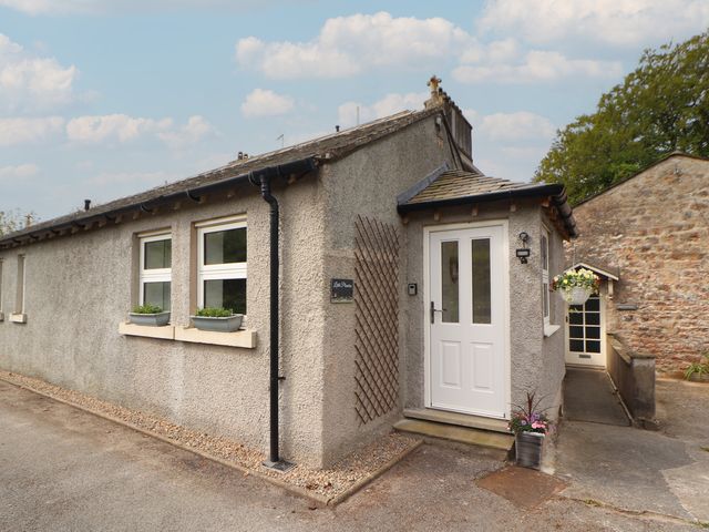 A cottage exterior with a door and windows at Little Plumtree in Milnthorpe