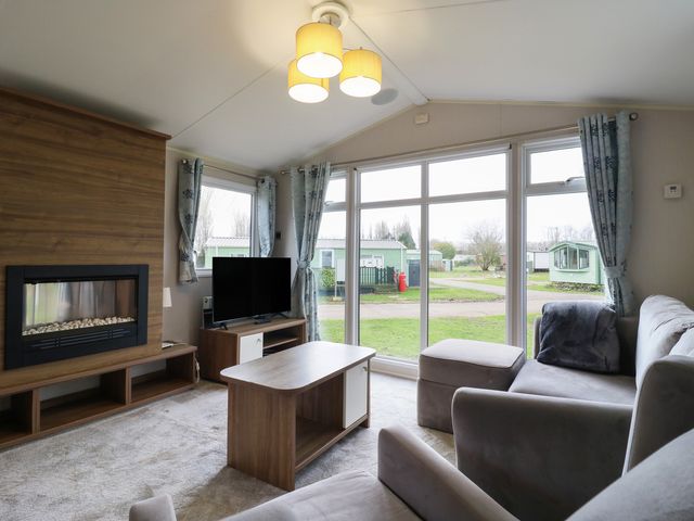 A living room with a fireplace and television at MP61 MP Billing Aquadrome Holiday Park Northampton