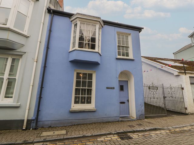 A blue house with a gate at 1 Alpha Cottages in Tenby