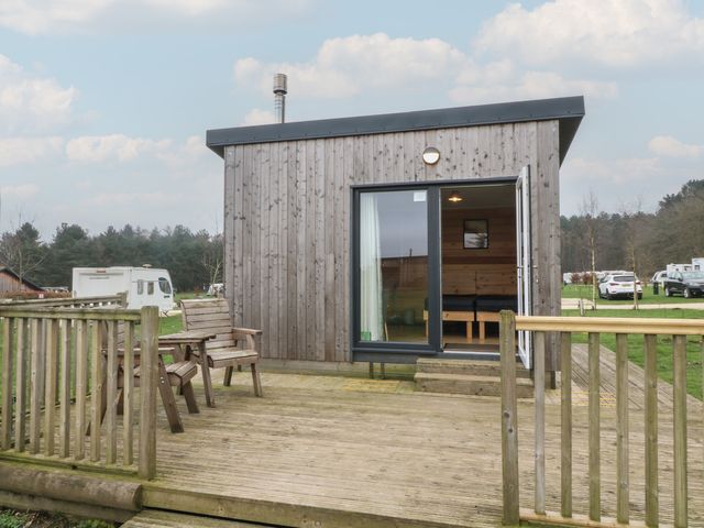 A cabin with a deck and chairs at Sherwood - Cosy Pod 1