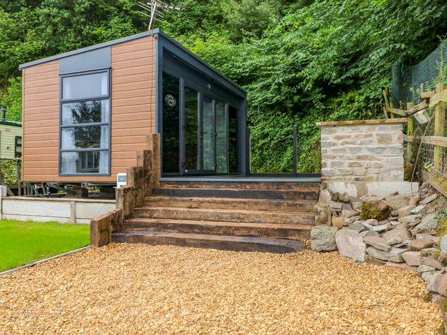 An outdoor view of a modern building with steps and gravel at The Pod in Ferryside