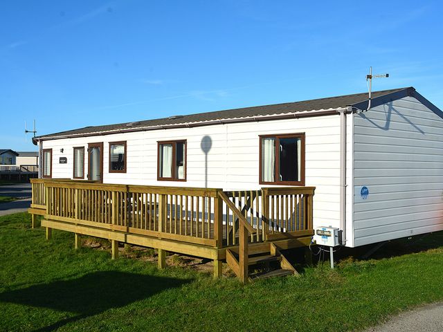 A mobile home with a deck and steps at 457 Pentreath View Perranporth