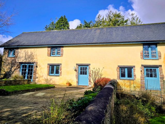 A house with blue windows and a door at Pylemoor Cottage Washfield near Tiverton