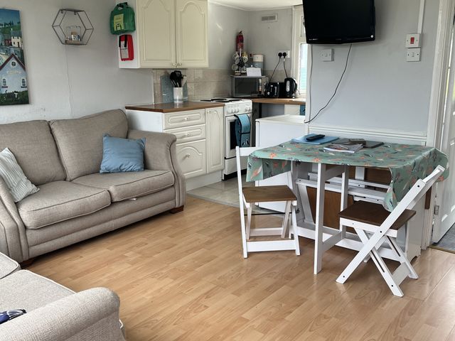 A living room with a sofa and a dining table at Chalet - Buckland 16 in Bideford