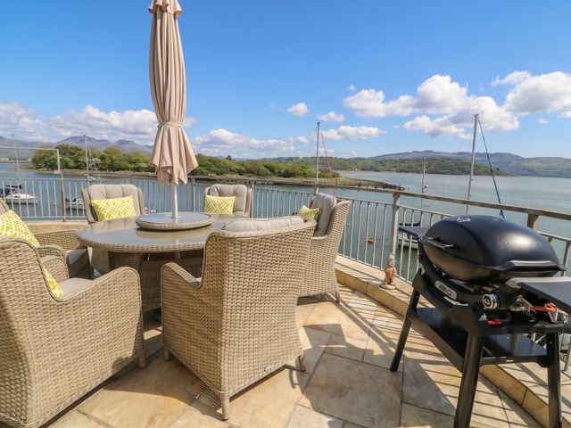 An outdoor patio with a table and chairs along with a barbecue grill at The Boat Yard Apartment Porthmadog