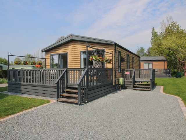 A modular home with a deck and garden in Poppy Eardisland