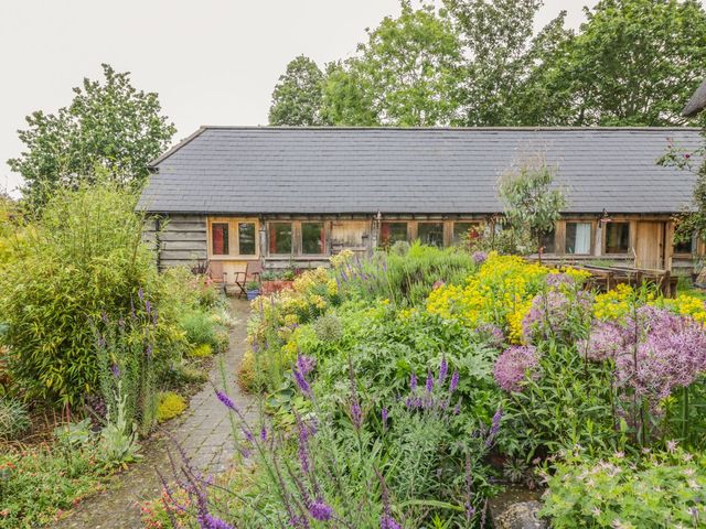 A garden with flowers and a building at Ryepiece in Stratford-upon-Avon