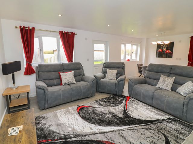 A living room with sofas and a lamp at Ruby Red in Brigg
