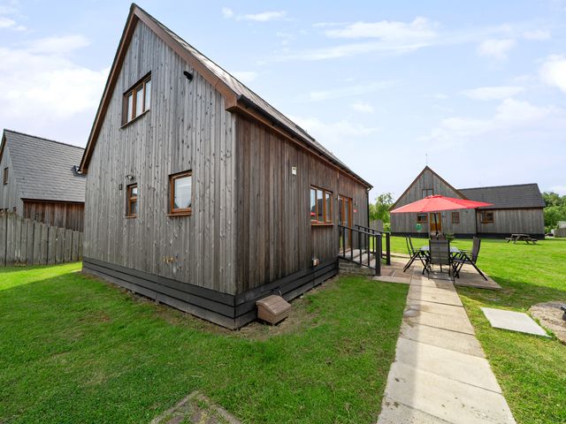 A wooden house with a garden and patio at Ruby Red near Brigg