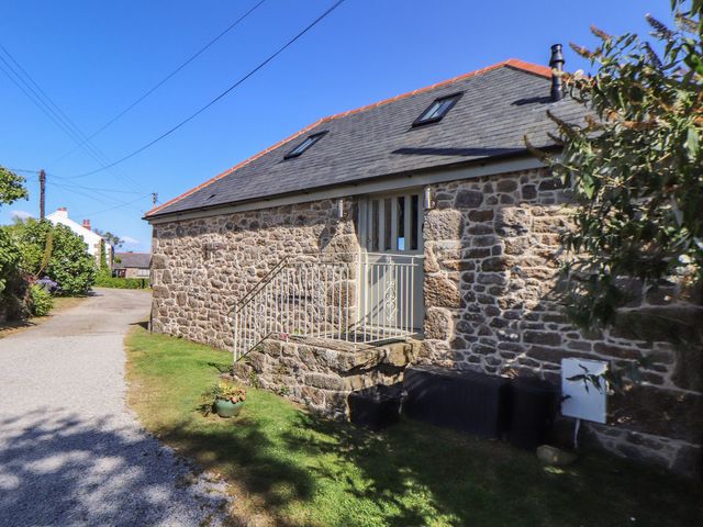 A stone cottage exterior with a pathway and steps at The Old Byre in Falmouth