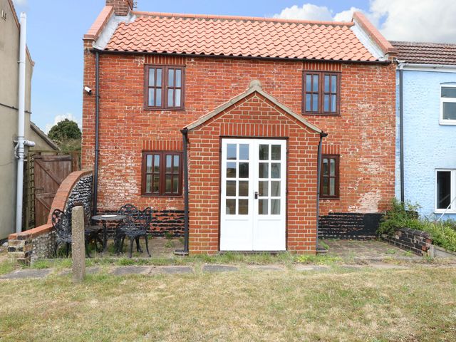 An outdoor view of a brick house with a patio and garden at Mabby Great Yarmouth