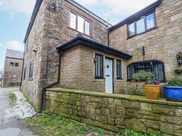 An exterior view of a stone house with a pathway at 2 Manor House farm in Higher Ogden near Newhey