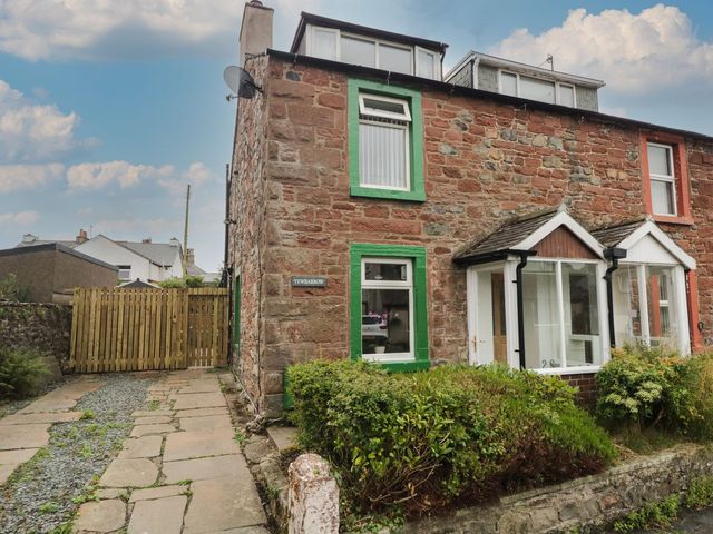 An exterior view of a house with a garden and pathway at Yewbarrow in Seascale