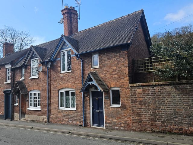 A brick house with windows and a door at Katie's Cottage in Church Stretton