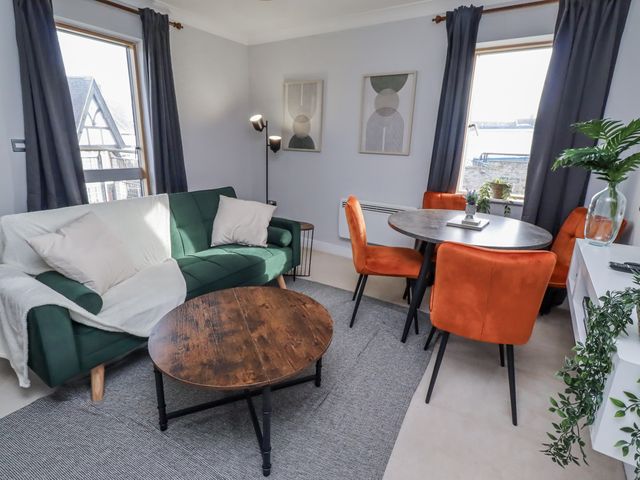 A living room with a sofa and dining table at 16 The Viking in Seahouses