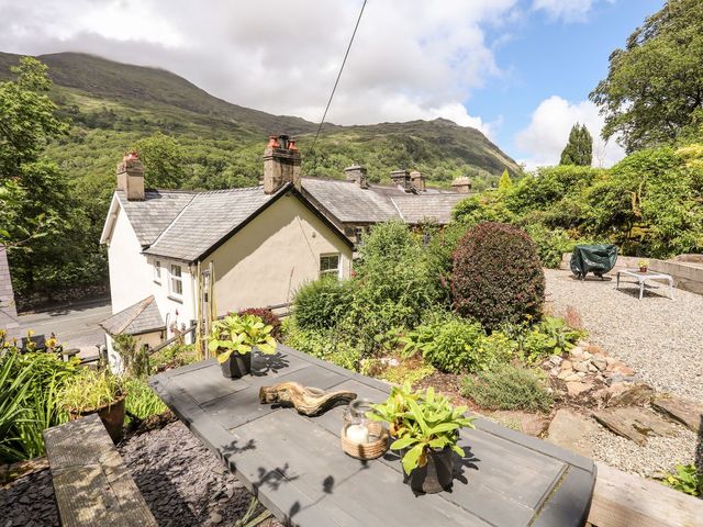 A garden view with a table and plants at Llys Elen in Caernarfon