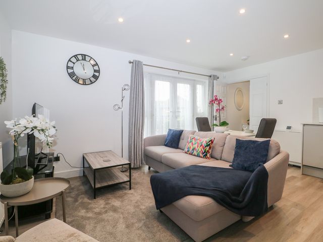 A living room with a clock and sofa at The Annex in Slough