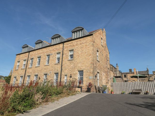 An outdoor view of a building with windows and a garden at The Sea Chest in Alnmouth