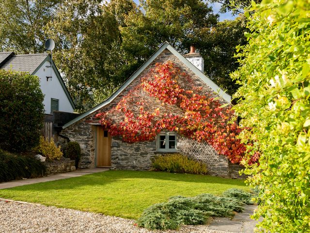 A cottage with a garden and gravel path at Ghillies Cottage Llandrillo