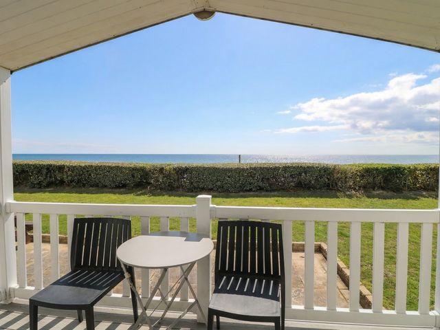 An outdoor area with chairs and a table overlooking the sea at Caravan in Great Yarmouth