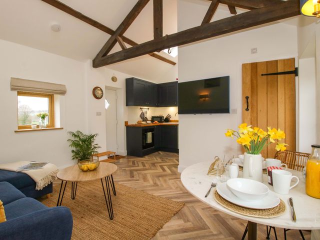 A living room with a dining area and kitchen unit at The Blacksmiths Shop 