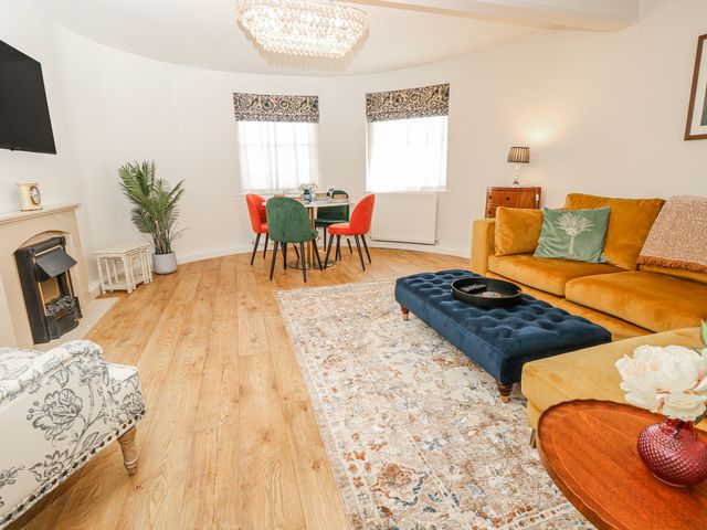 A living room with a sofa and dining area at 1A Clifton Road in Winchester