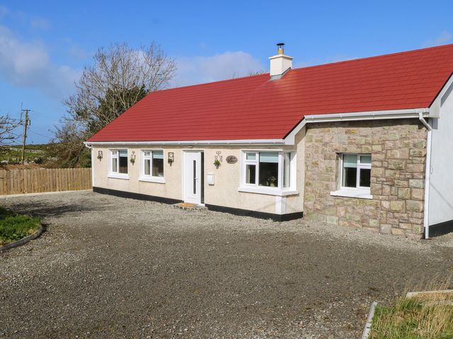 A house with a red roof and gravel driveway at Doire Fhatharta Beag in Carraroe, County Galway