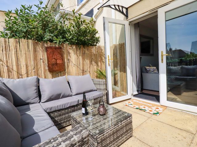 An outdoor patio with a sofa and table at Tolcarne Reach in Newquay