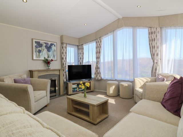 A living room with a television and sofa at Pheasant Lodge in Holyhead