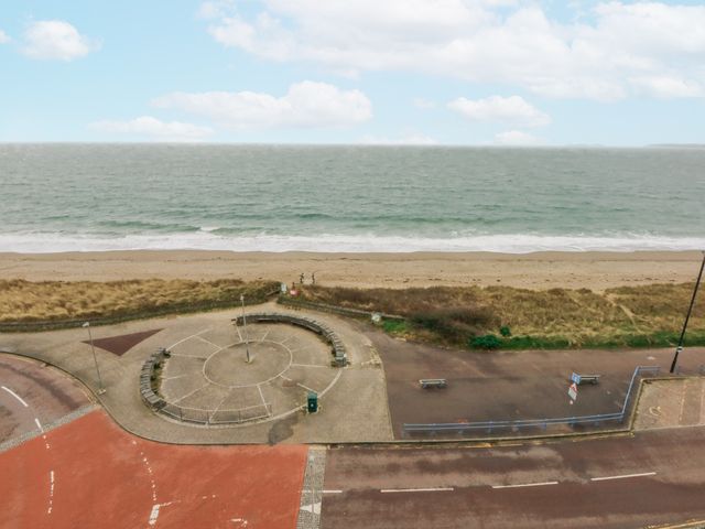 An outdoor beach area with sand and benches at Snowdonia View Pwllheli
