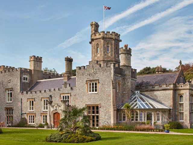 A castle with a flag and garden at Uphill Manor in Uphill near Weston-Super-Mare