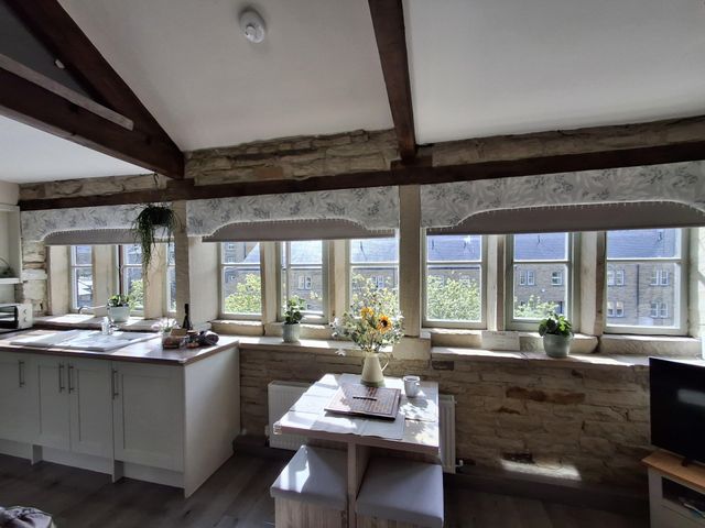 A kitchen with a table and chairs at Riverview Cottage in Holmfirth