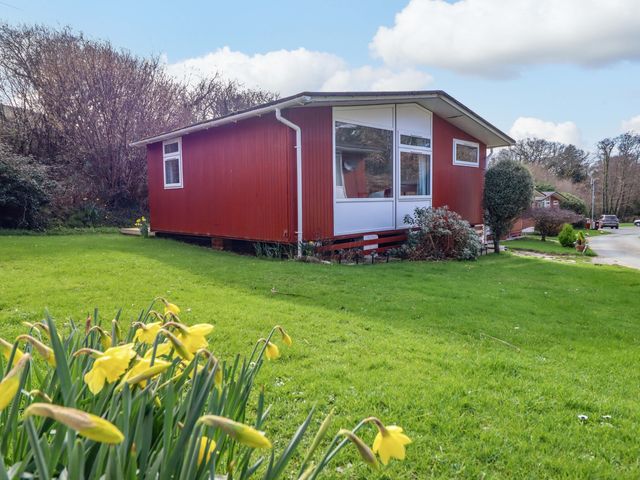 A house with windows and grass at Chalet 23 Erw Porthor Tywyn