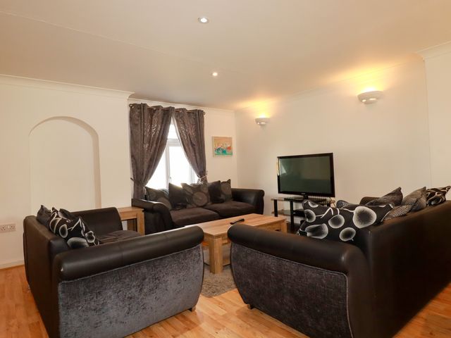 A living room with sofas and a television at 62 Golf Lodges Atlantic Reach near Fraddon