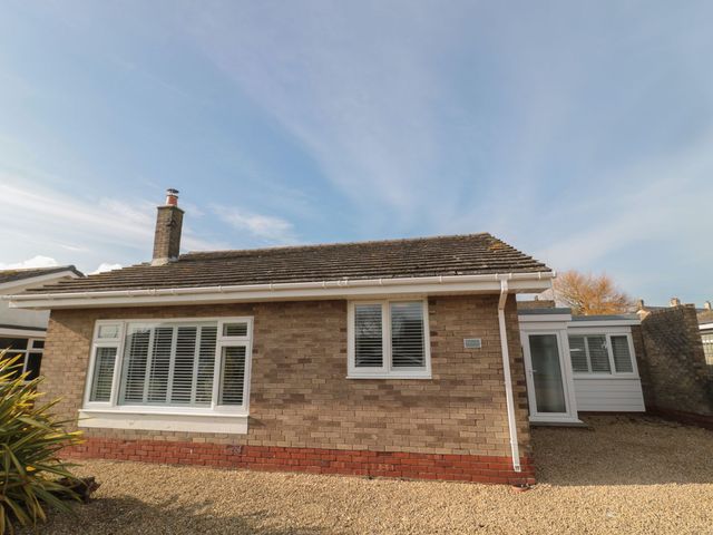 A bungalow exterior with windows and a gravel driveway at 7 Longstone Close Chathill