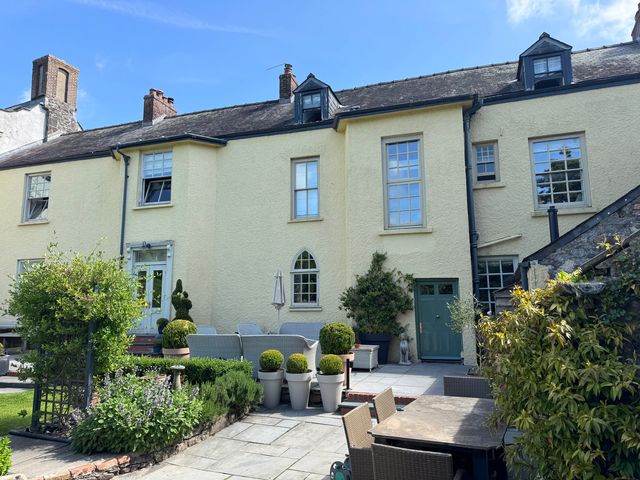 A house with garden furniture and planters at The Old Vicarage in Laugharne
