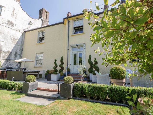 A garden with a house and patio furniture at The Old Vicarage in Laugharne