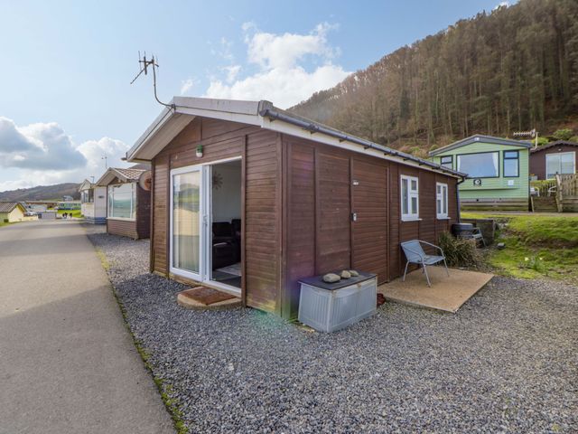 A cabin with a gravel area and outdoor furniture at The Comfort Den near Aberystwyth